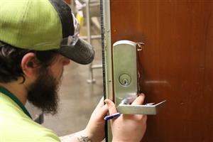 Worker installing new door lock